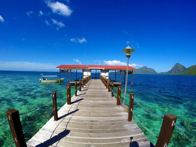 Pier over sea against blue sky