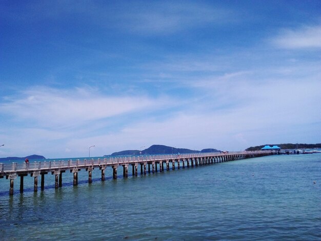 Pier over sea against blue sky