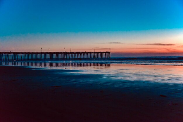 Pier over sea against blue sky