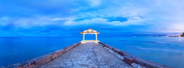 Pier over sea against blue sky