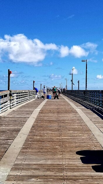 Pier over sea against blue sky