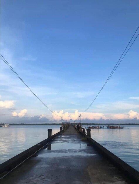 Pier over sea against blue sky