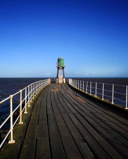 Photo pier over sea against clear blue sky