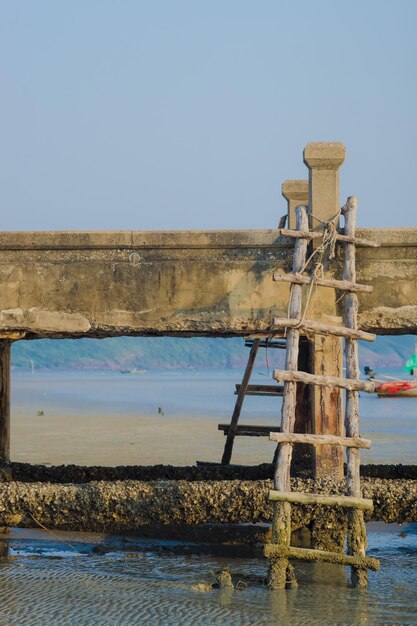 Pier over sea against clear blue sky