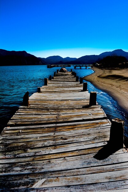 Photo pier on sea against clear blue sky