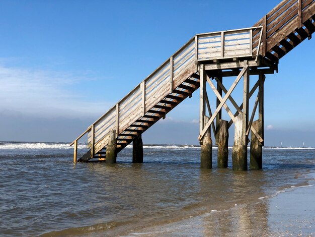 Pier over sea against clear sky