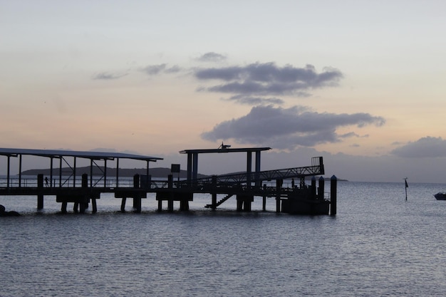 Photo pier over sea against sky during sunset