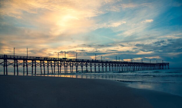 Photo pier over sea against sky during sunset