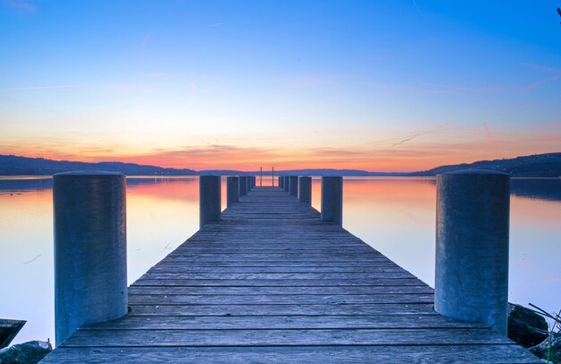 Photo pier over sea against sky during sunset