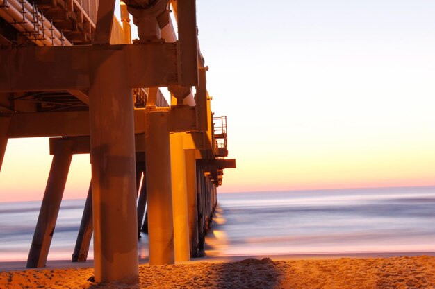 Photo pier over sea against sky during sunset