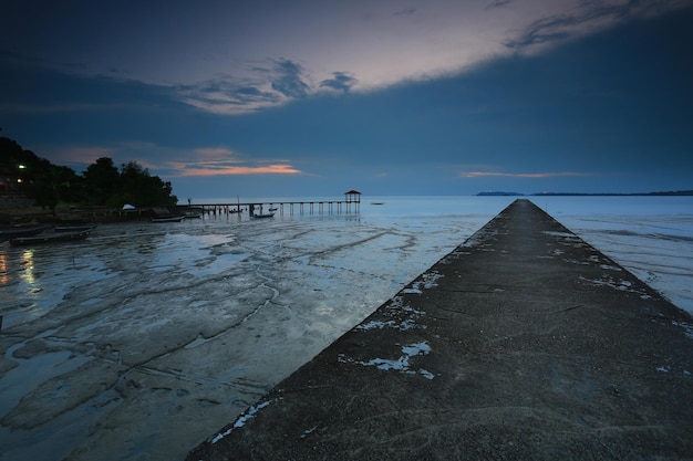 Photo pier over sea against sky during sunset