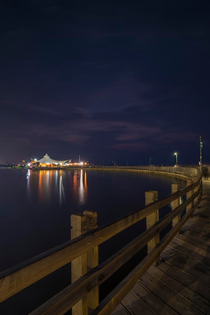 Pier over sea against sky at night