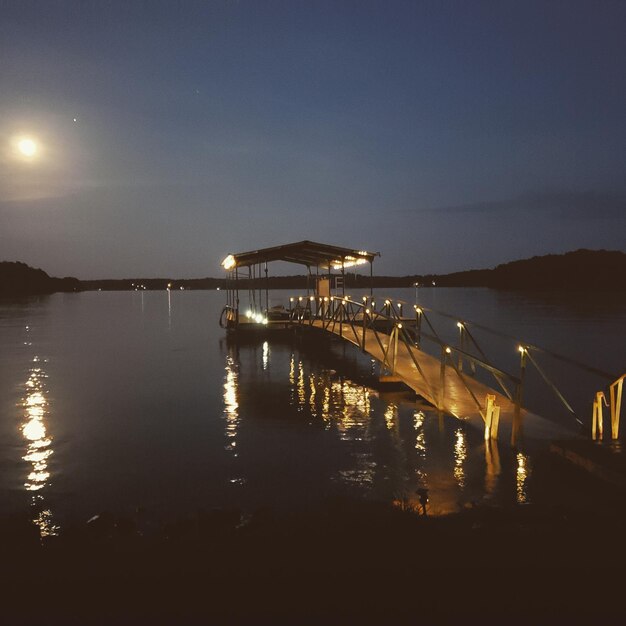 Pier over sea against sky at night