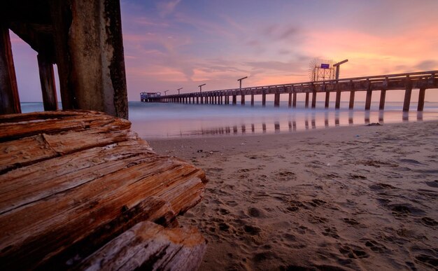 Pier over sea against sky during sunset