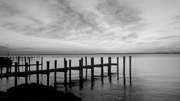 Pier on sea against sky during sunset