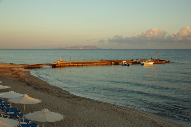 Pier in the sea at dawn with motor boats