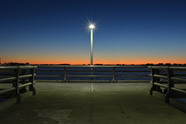 Pier on sea at sunset