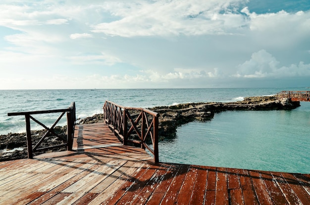 Pier sea view coral beach of Caribbean sea wooden bridge on sea Riviera Maya Mexico wooden walkway