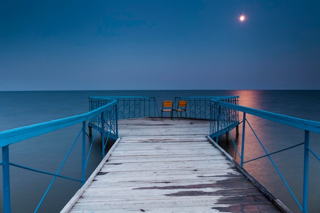 Pierce with two chairs against a nightscape