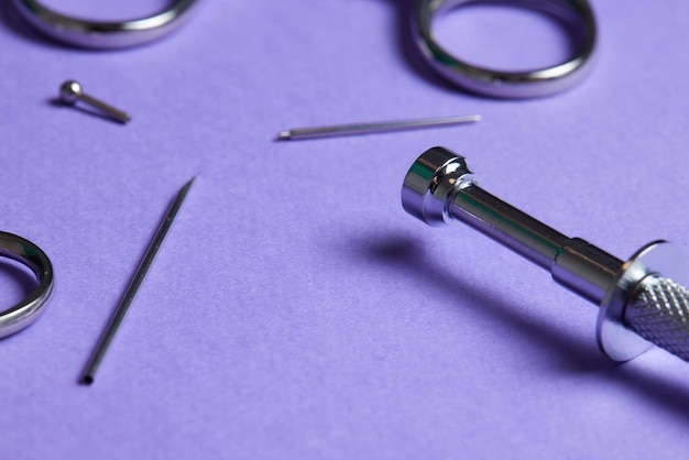 Piercing earrings closeup on a violet background