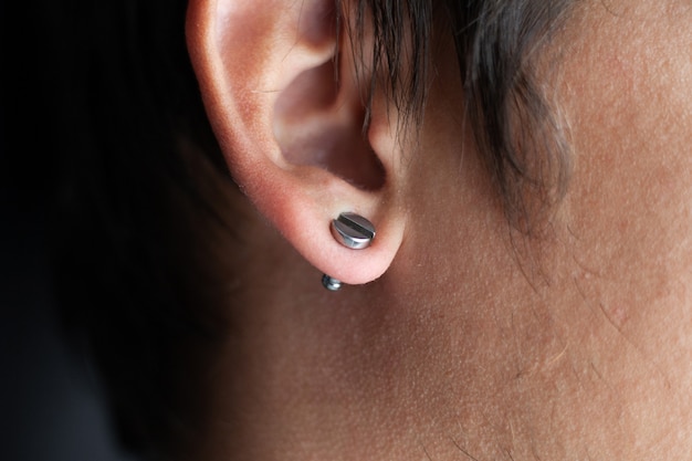 Piercing in a man's ears closeup,ear tunnel.