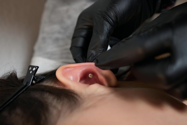 Piercings on an ear conch and helix piercings close up