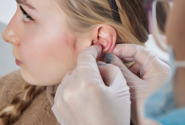 Piercings op een oorschelp en helix piercings close-up