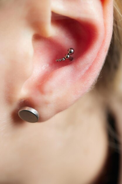 Piercings op een oorschelp en helix piercings close-up