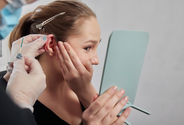 Piercings op een oorschelp en helix piercings close-up