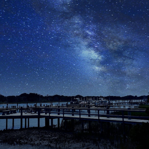 Photo piers over sea against star field in blue sky