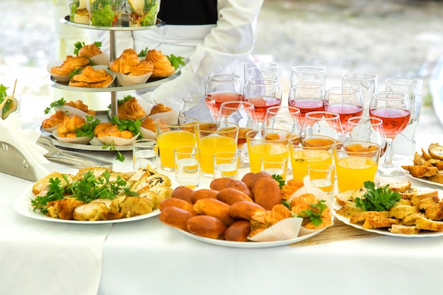 Pies, eclairs and drinks on a banquet table