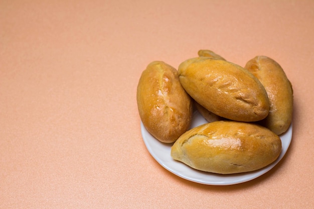 Pies with meat cabbage or any filling Baked pies in the oven On a white plate