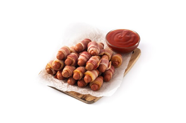 Pig in blankets. Sausages wrapped in smoked bacon isolated on white