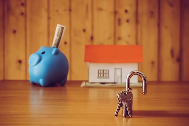 Pig money box and paper decor on wooden wall background