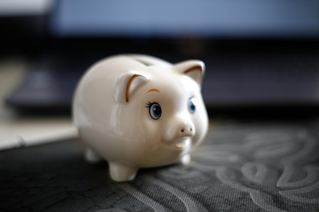 Piggy bank against the background of a laptop selective focus