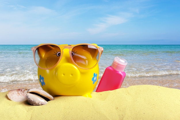 Piggy bank on a beach. Vacation savings concept