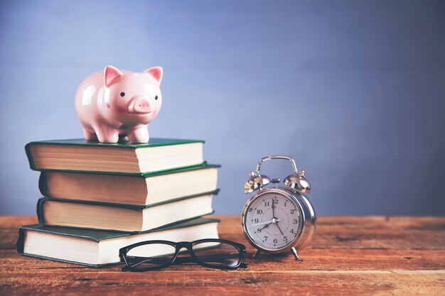 Piggy bank and clock on book