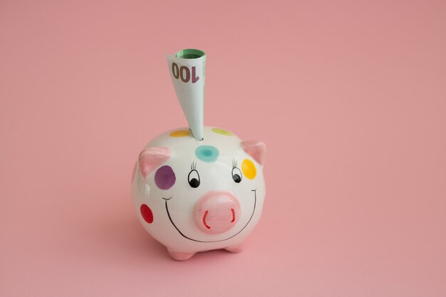 Photo piggy bank in the form of a pig on a pink background.