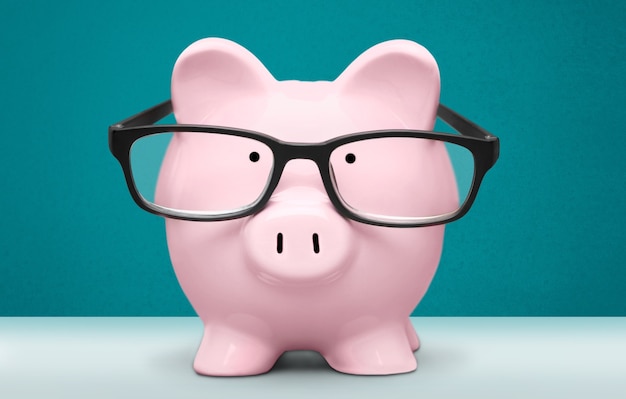 Piggy bank in glasses on background