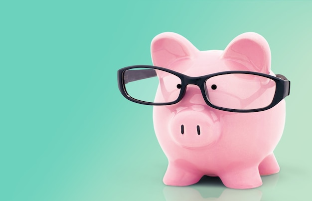 Piggy bank in glasses on background