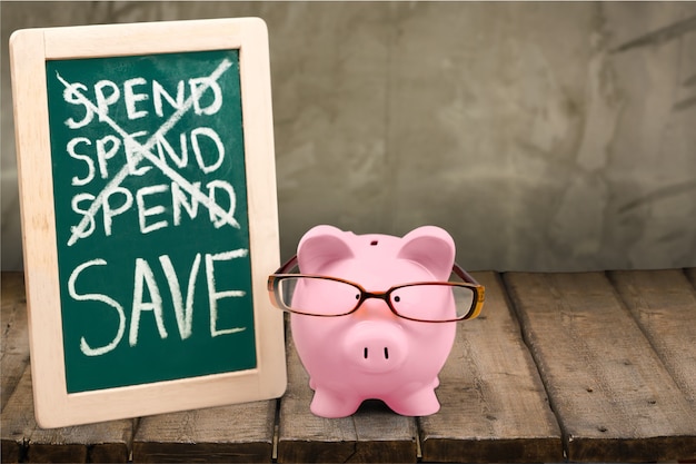 Photo piggy bank in glasses and deck on wooden table at wall background