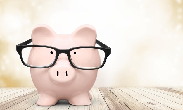 Piggy bank in glasses on wooden table