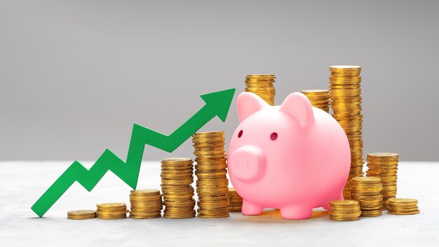 Piggy bank and green up arrow with coins on a gray background Growth of cash savings