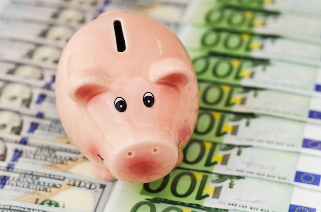 Piggy bank honderd dollarbiljetten en eurobiljetten van verschillende coupures