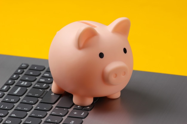 Piggy bank on laptop keyboard closeup