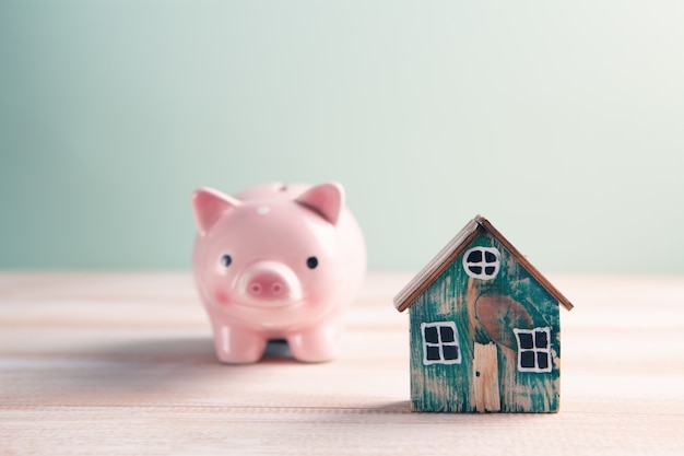 Piggy bank and model house piled up for home