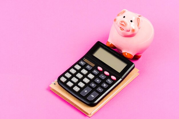 Piggy bank pink pig and calculator. Business administration. Finance manager job position. Trading exchange. Trade market. Finance control. Credit concept. Economics and finance. Calculate profit.