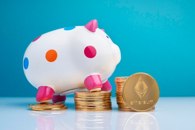 Piggy bank on stacked coins over table against wall