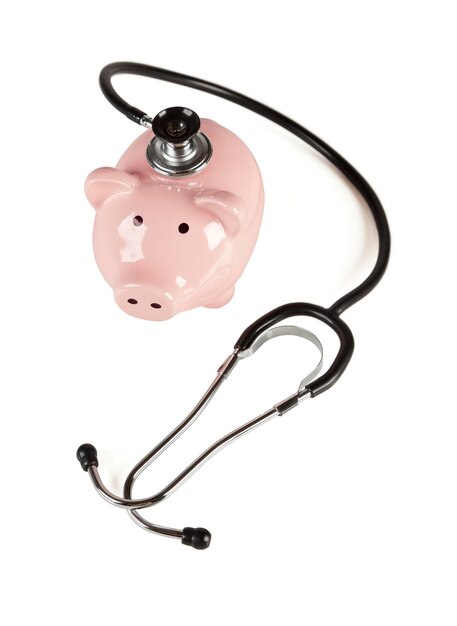 Photo piggy bank and stethoscope isolated on a white background with slight shadow