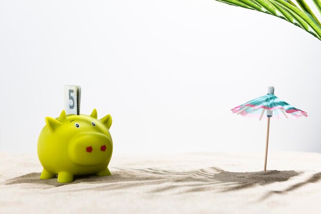 Piggy bank on sunny beach Savings for vacation concept